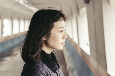 Rear view of woman looking through window