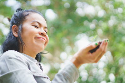 Portrait of smiling young man using mobile phone outdoors