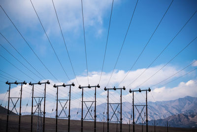 Low angle view of power lines against sky