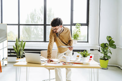 Illustrator working with tablet pc and laptop at desk in office