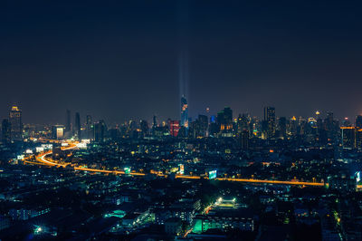 Illuminated cityscape against sky at night