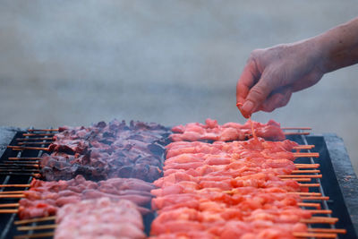 Midsection of person preparing food on barbecue grill