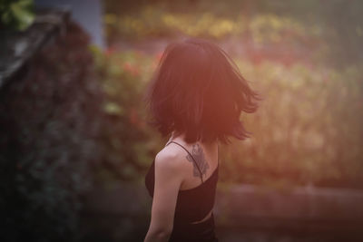 Portrait of woman standing against blurred background