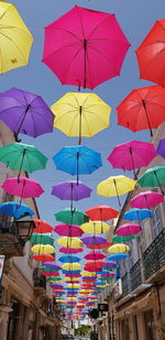 Low angle view of umbrellas hanging against sky