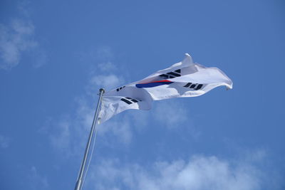 Low angle view of crane against blue sky