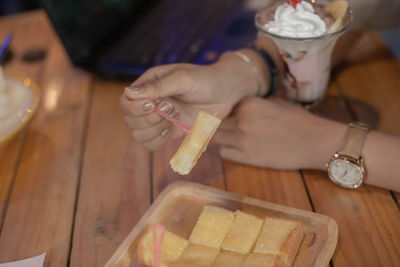 High angle view of woman holding cigarette on table