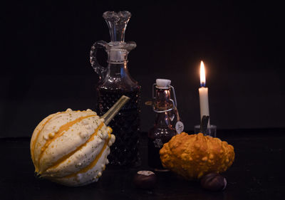 Close-up of burning candles against black background