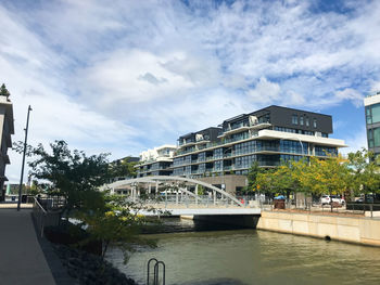 Bridge over river in city against sky