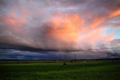 Scenic view of field against cloudy sky