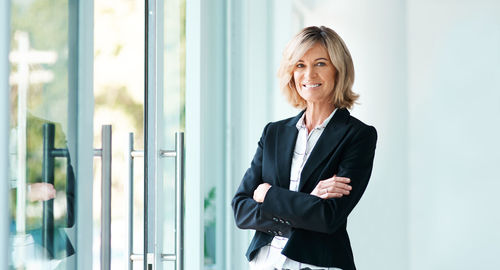 Portrait of businesswoman standing against wall