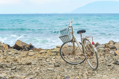 Bicycles on beach against sky