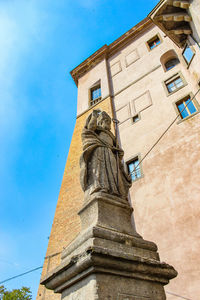 Low angle view of cross on building against sky