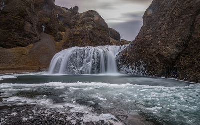 Full frame view of icy waterfall in rugged terrain