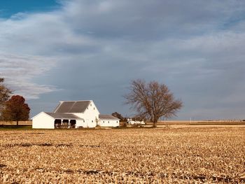 Barn in field against sky