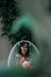 Portrait of woman holding plant