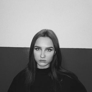 Portrait of beautiful young woman standing against wall