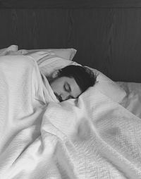 High angle view of man sleeping on bed at home