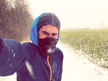 Portrait of young man standing in field