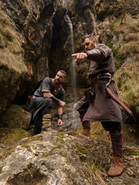 Full length of warriors standing on rock in forest