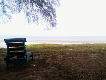 Empty bench overlooking calm sea