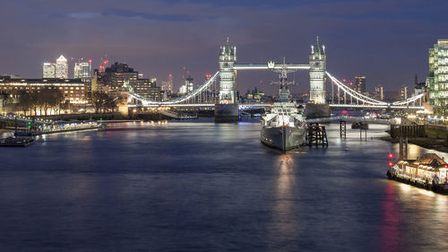 Illuminated tower bridge over thames river in city at night