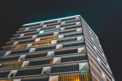 Low angle view of illuminated buildings against clear sky at night