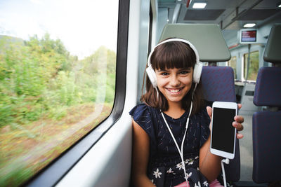 Portrait of a smiling young woman in train