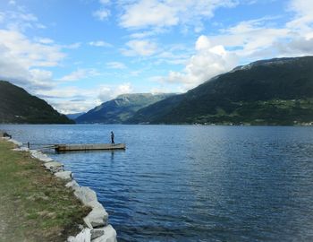 Scenic view of lake by mountains against sky