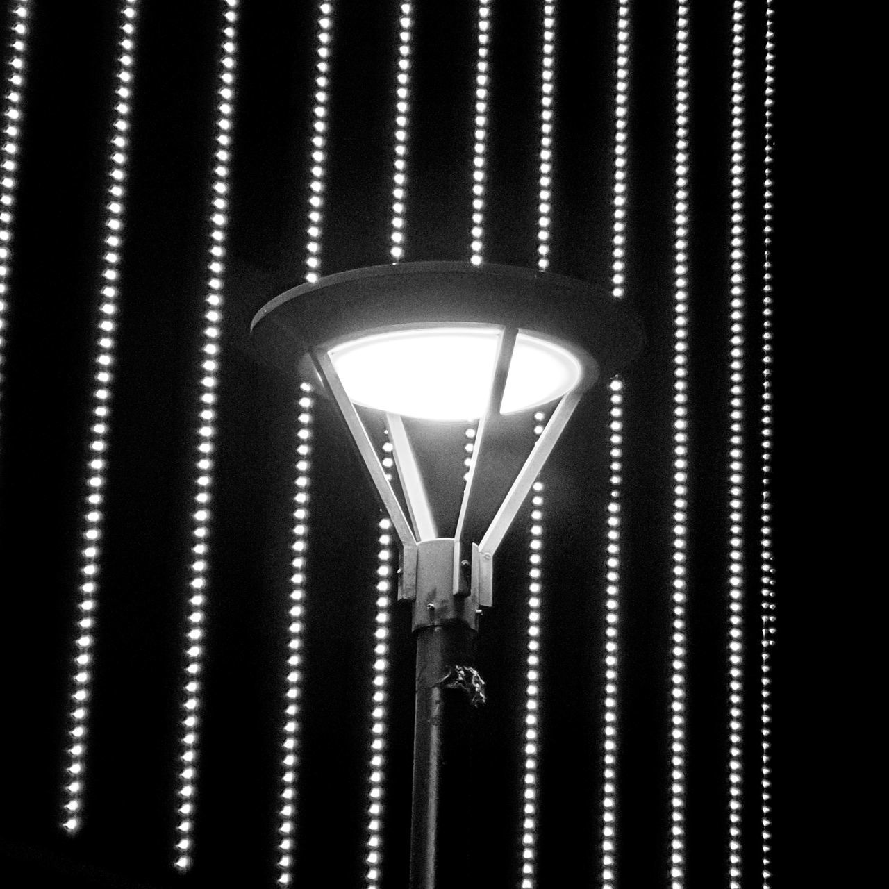 lighting equipment, illuminated, street light, no people, electricity, low angle view, electric light, light fixture, night, light, indoors, light bulb, glowing, lighting, electric lamp, metal, black and white, pattern, light - natural phenomenon, darkness, hanging, technology