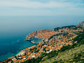 High angle view of townscape by sea against sky