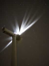 Low angle view of windmill against star field at night