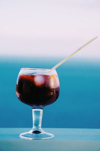 Close-up of drink on table against sea