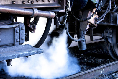 Cropped image of train emitting smoke on railroad track