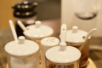 Close-up of containers with condiment shaker on table