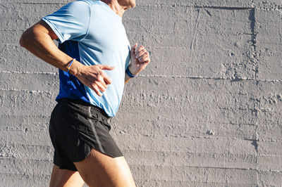 Midsection of man holding wall