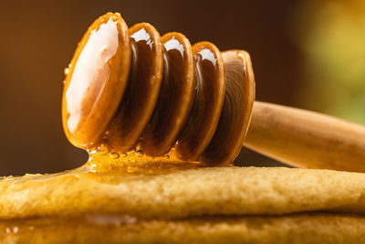 Honey dripping from a wooden spoon