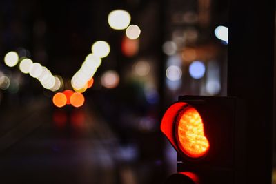 Close-up of illuminated stoplight in city at night