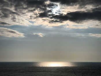 Sunlight streaming through clouds over sea