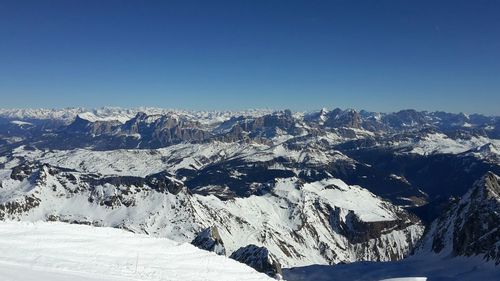 Scenic view of snowcapped mountains against clear blue sky