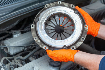 Close-up of hand holding orange wheel