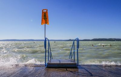 Lifeguard hut on beach against clear blue sky