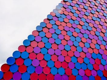 Low angle view of multi colored pencils against blue sky