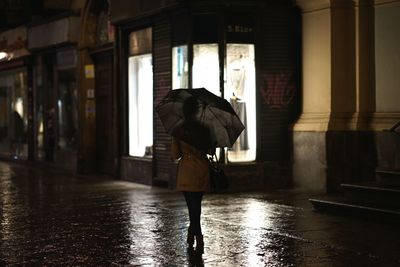 Rear view of a man walking in rain