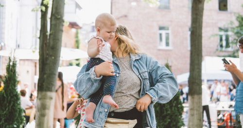 Rear view of mother with daughter standing outdoors