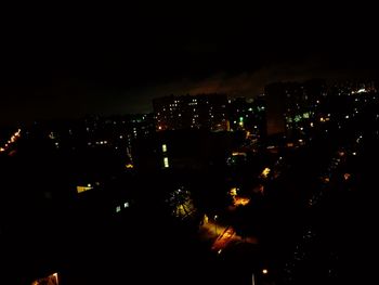 Illuminated cityscape against sky at night