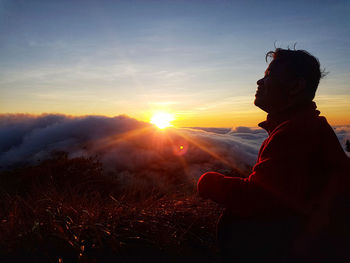 Midsection of man against sky during sunset