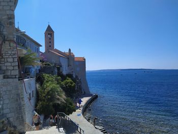 Panoramic view of sea and buildings against clear blue sky