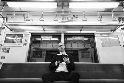 Lone man on subway reading book