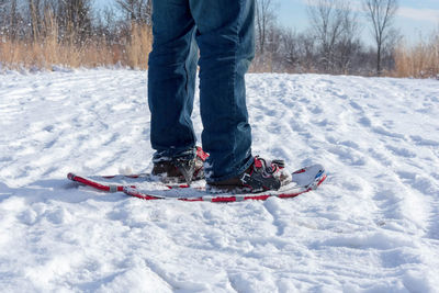 Low section of man snowshoeing on snow