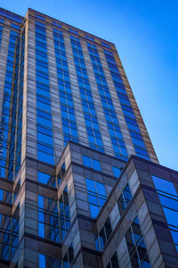 Low angle view of modern building against blue sky